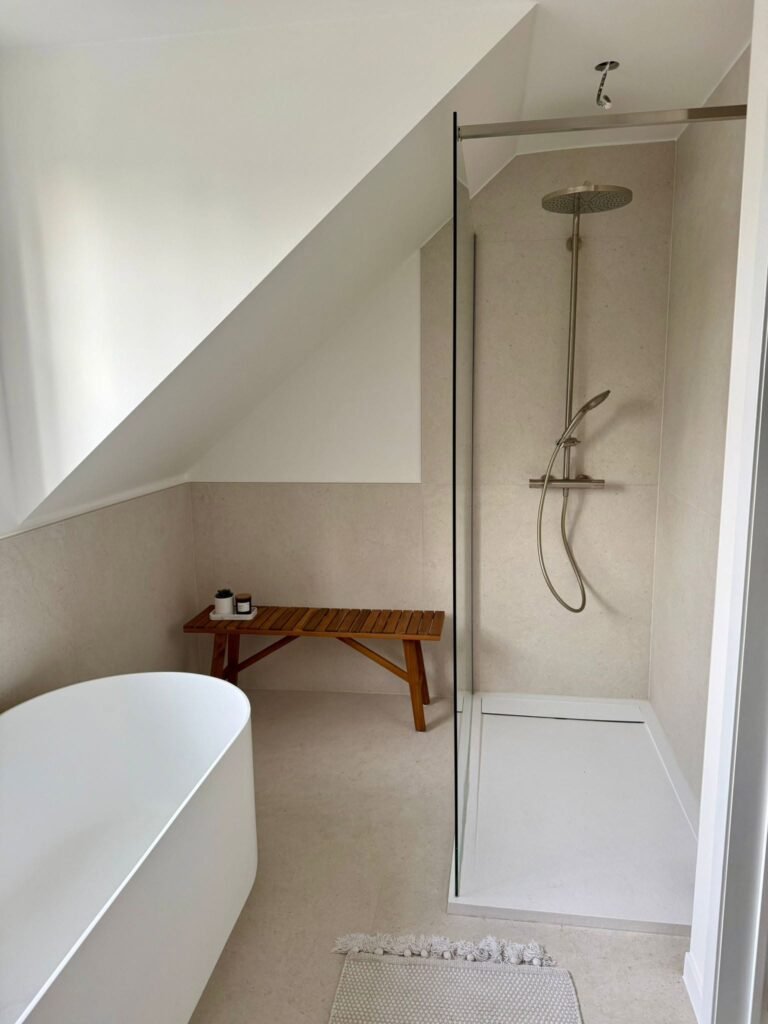 Salle de bain sous combles avec douche italienne et baignoire îlot